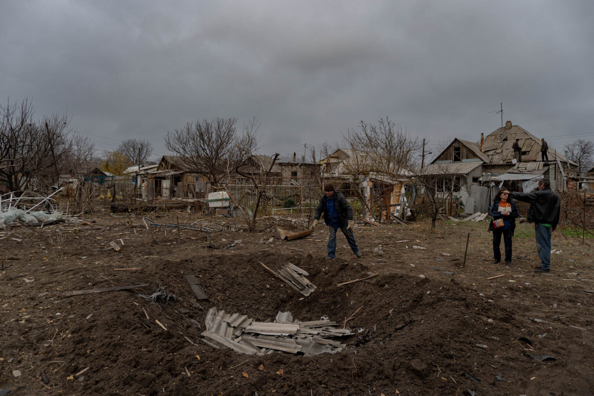Residents clean their yard and home in the morning after a strike in their garden
